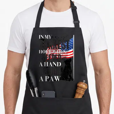 Darkest cute pet apron - Distressed flag behind stacked text and black sitting dog silhouette — shown on a black cotton canvas apron against a white background