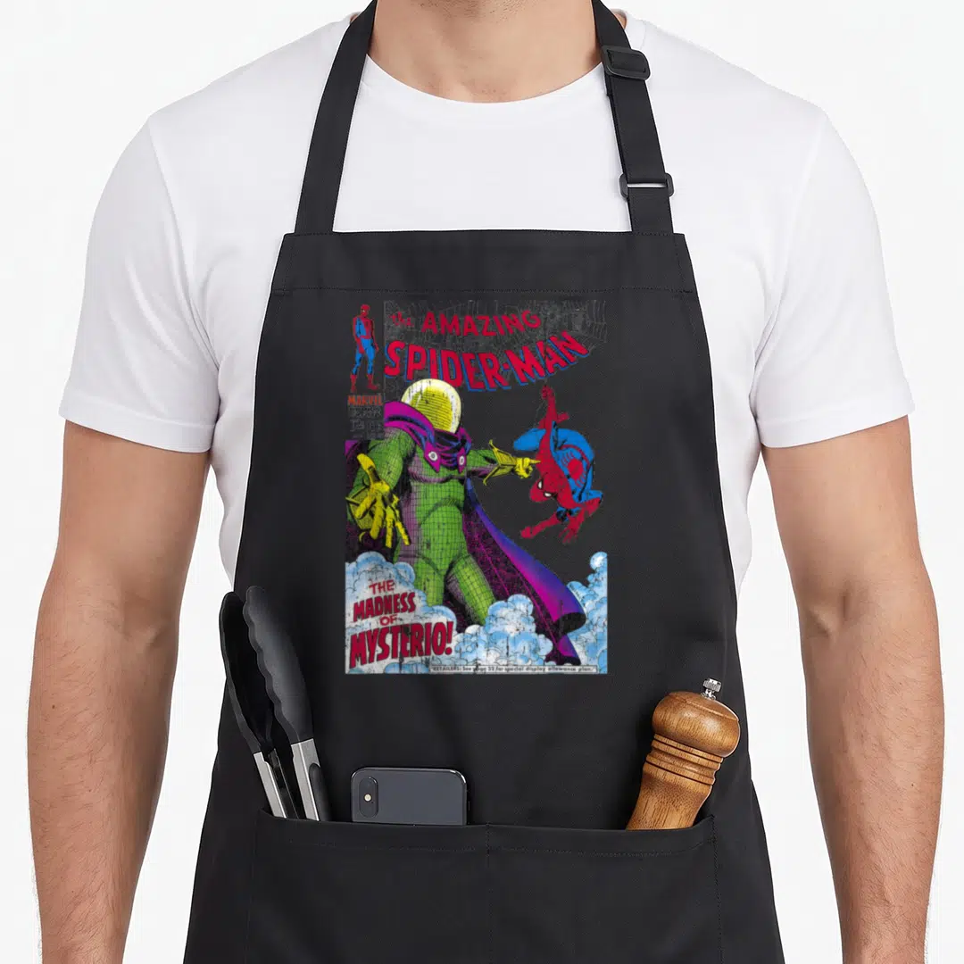 Mysterio cover apron - Mysterio comic cover with Spider-Man hanging and standing beside him, red and green art — shown on a black cotton canvas apron against a white background