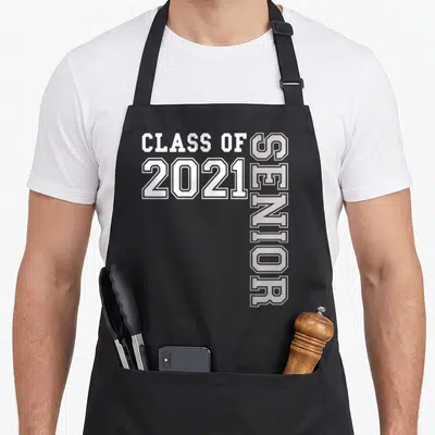 Class miss grade apron - White and grey Class of 2021 Senior typography design with vertical text — shown on a black cotton canvas apron against a white background