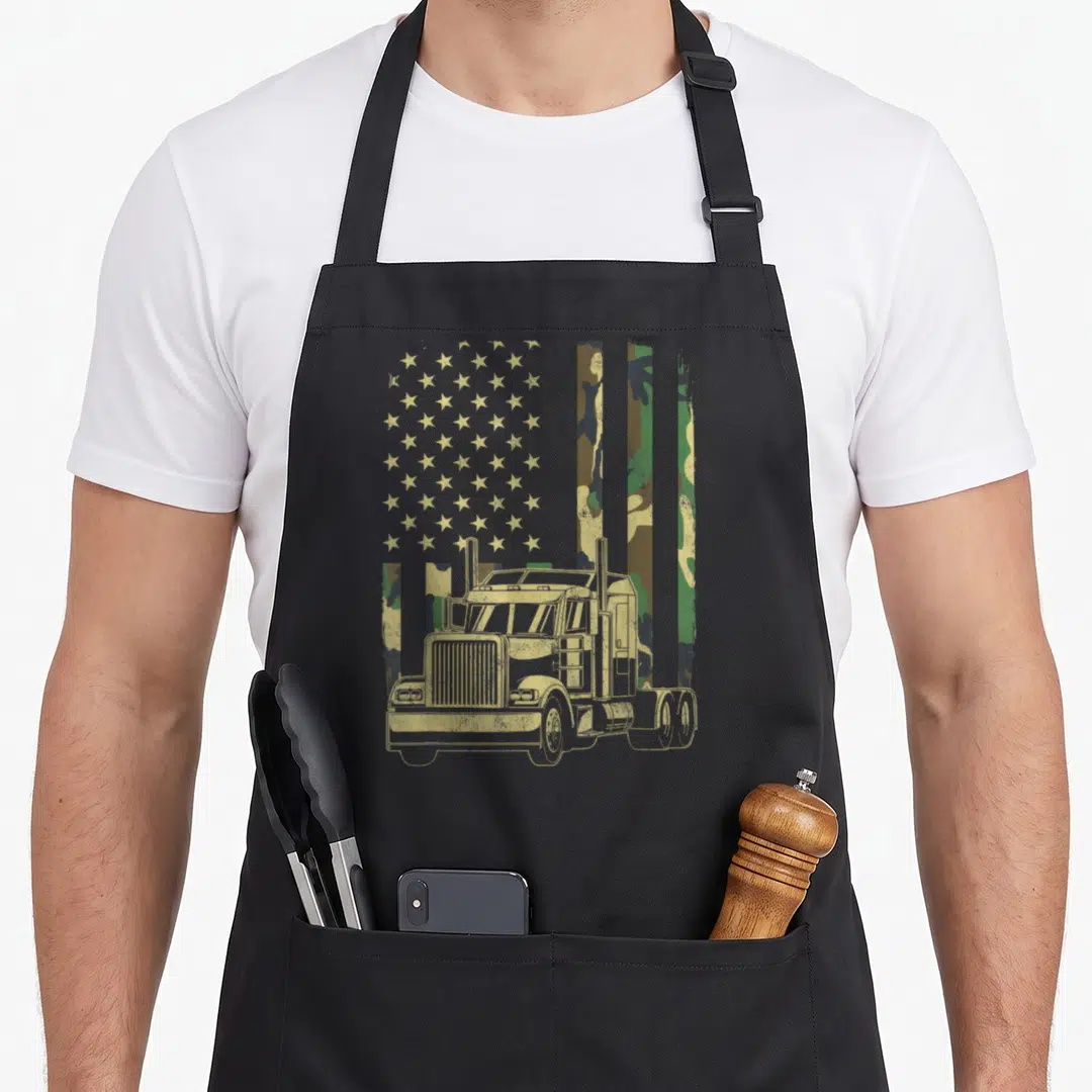 Trucker camouflage american flag apron - Tan semi-truck over stars and camo stripes with distressed finish — shown on a black cotton canvas apron against a white background