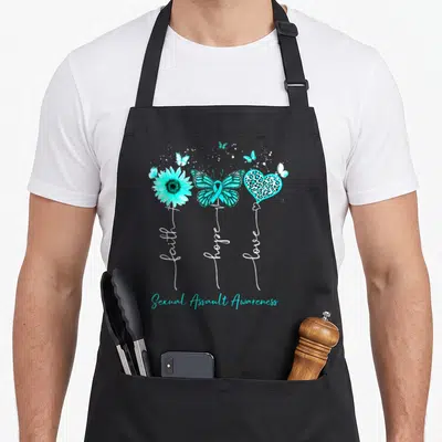 Sexual sunflower apron - Teal sunflower, ribbon butterfly, leopard heart with vertical faith hope love text — shown on a black cotton canvas apron against a white background