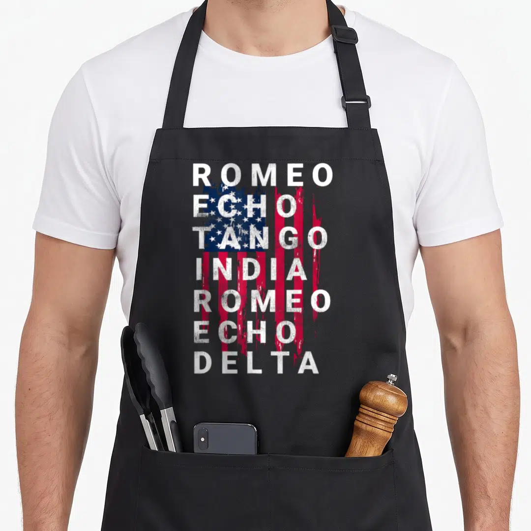 Retired military apron - Stacked white text ROMEO ECHO TANGO INDIA over distressed USA flag — shown on a black cotton canvas apron against a white background