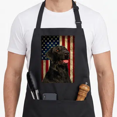 Flag labrador apron - Black labrador portrait over distressed red white and blue USA flag — shown on a black cotton canvas apron against a white background
