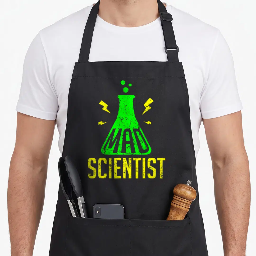 Costume science apron - Green Erlenmeyer flask with MAD inside, yellow SCIENTIST text, and lightning bolts — shown on a black cotton canvas apron against a white background