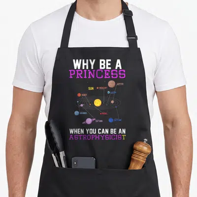 Funny astrophysicist princess apron - Solar system diagram with text Why be a Princess When You Can Be — shown on a black cotton canvas apron against a white background