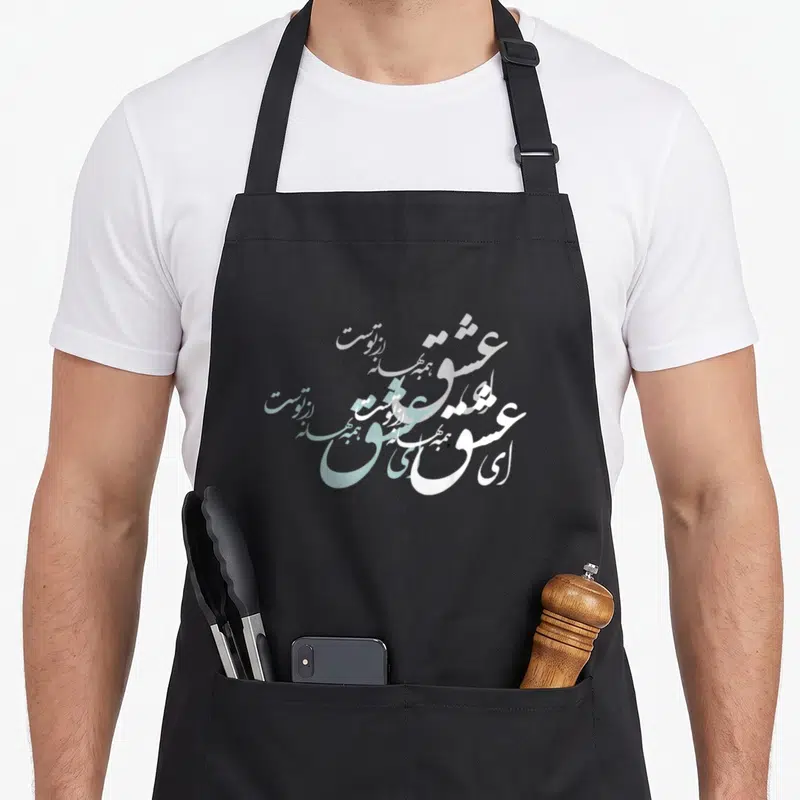 Norouz calligraphy apron - White and light blue Persian calligraphy script reading Ey Eshgh — shown on a black cotton canvas apron against a white background