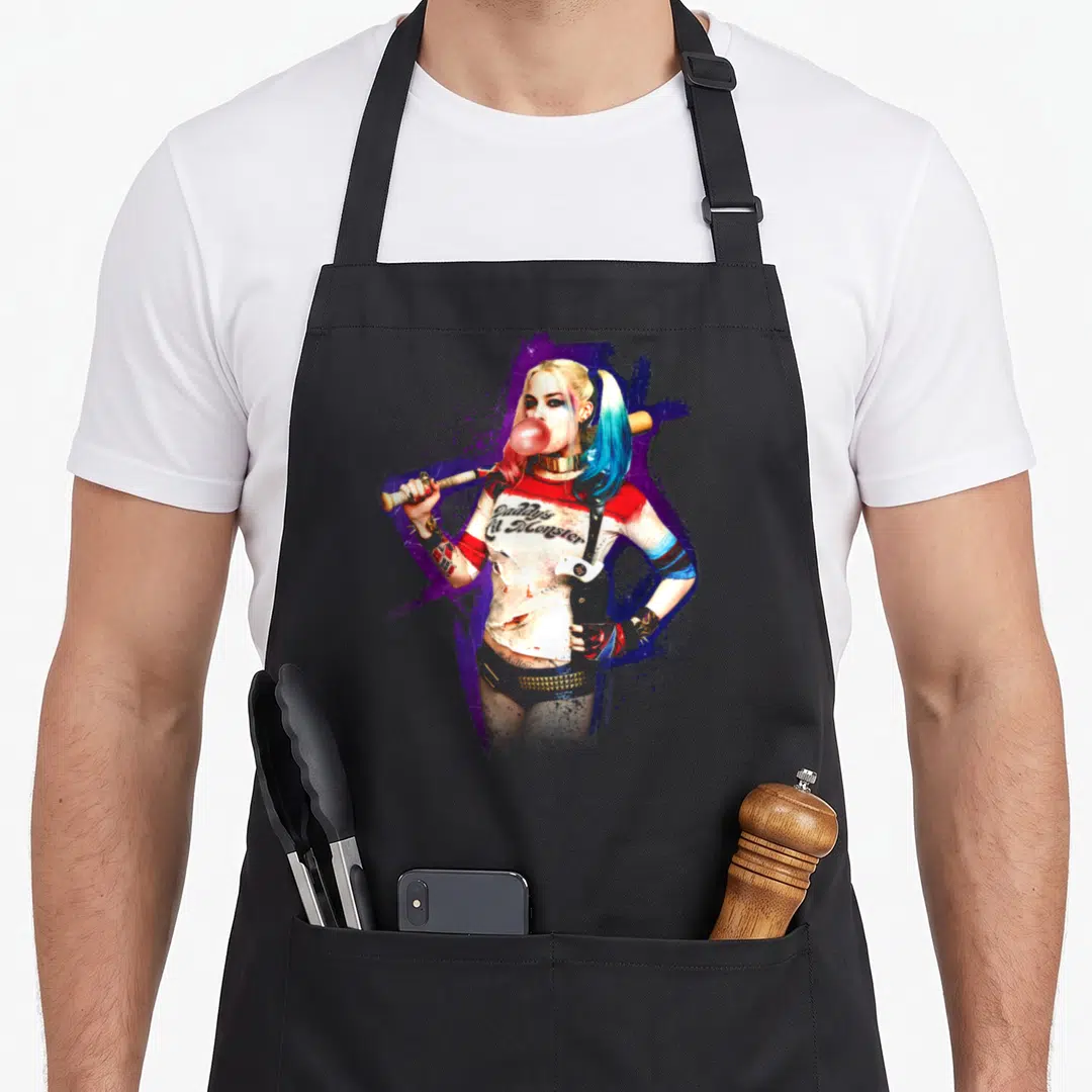 Squad bubble vehicle apron - Harley Quinn holding a bat with Daddy's Little Monster text on purple blue splatter — shown on a black cotton canvas apron against a white background
