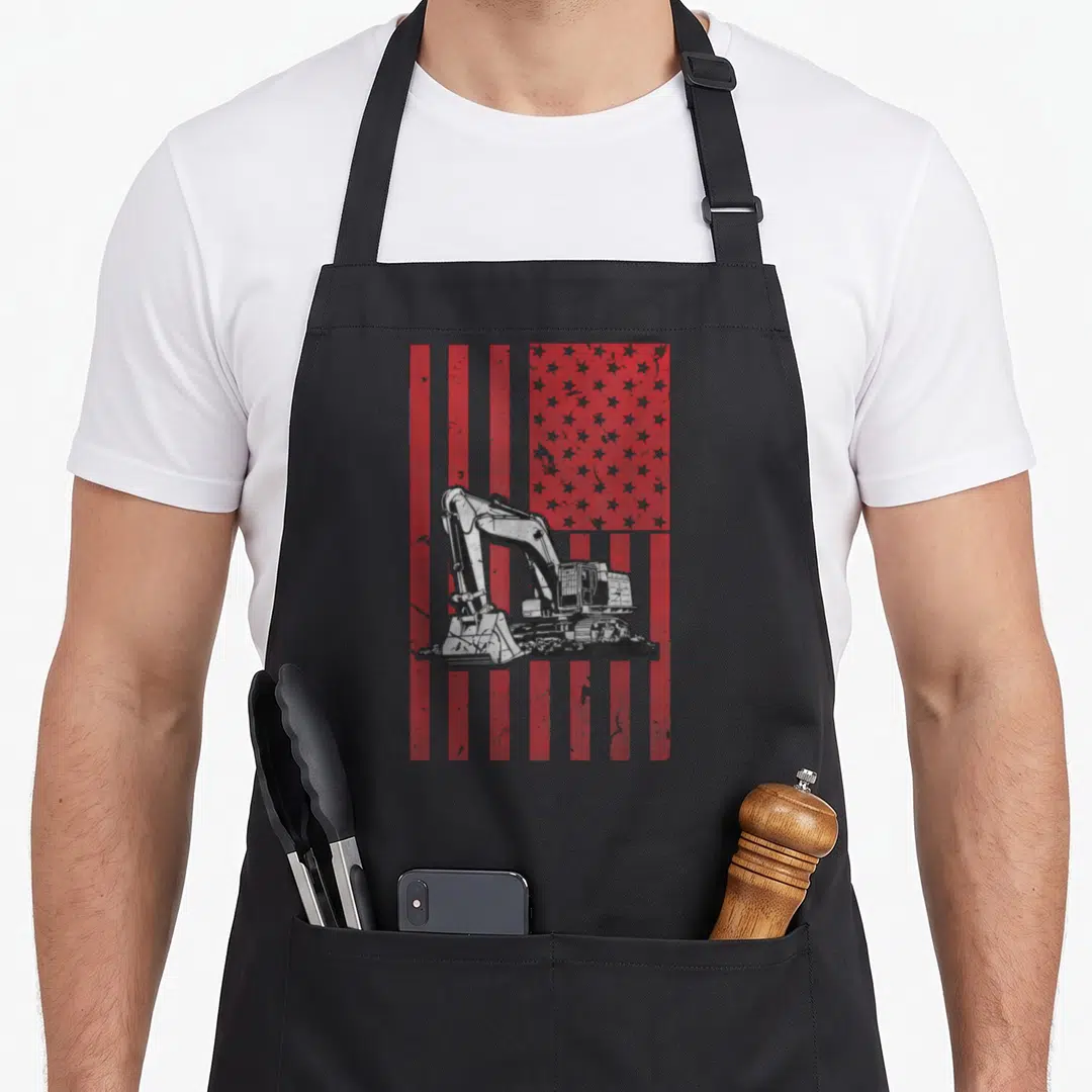 Flag equipment heavy canvas aprons - Centered excavator silhouette over distressed red and grey US flag pattern — shown on a black cotton canvas apron against a white background