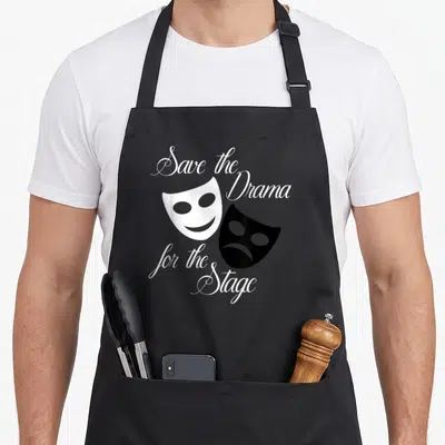 Save theater apron - Two drama masks and script text reading save the Drama for the Stage — shown on a black cotton canvas apron against a white background