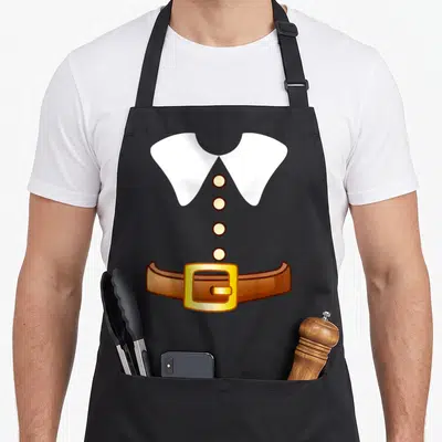 Thanksgiving costume pilgrim apron - Cartoon white collar, four yellow buttons, brown belt with yellow buckle on grey — shown on a black cotton canvas apron against a white background