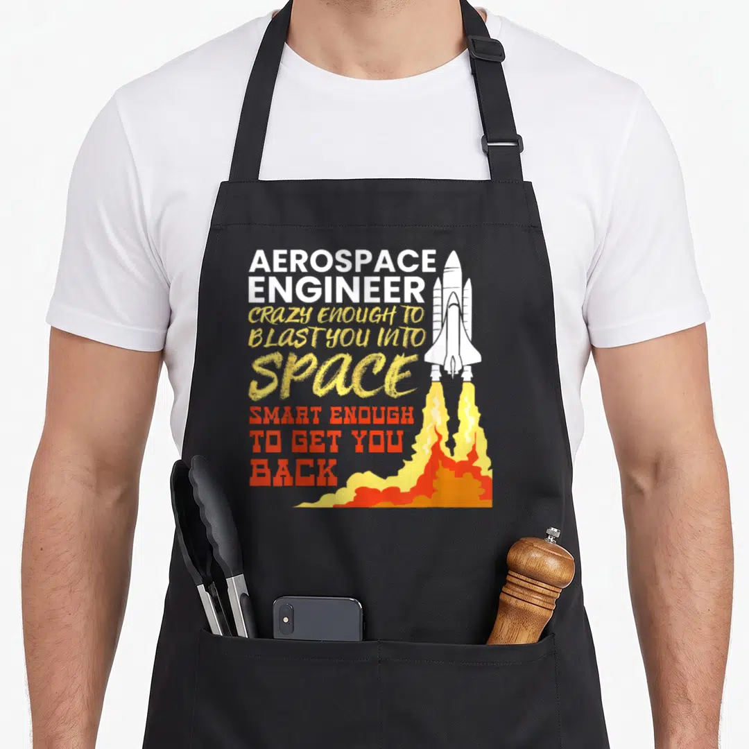 Aerospace engineering engineer apron - Space shuttle with white yellow red and orange flame and stacked engineering — shown on a black cotton canvas apron against a white background