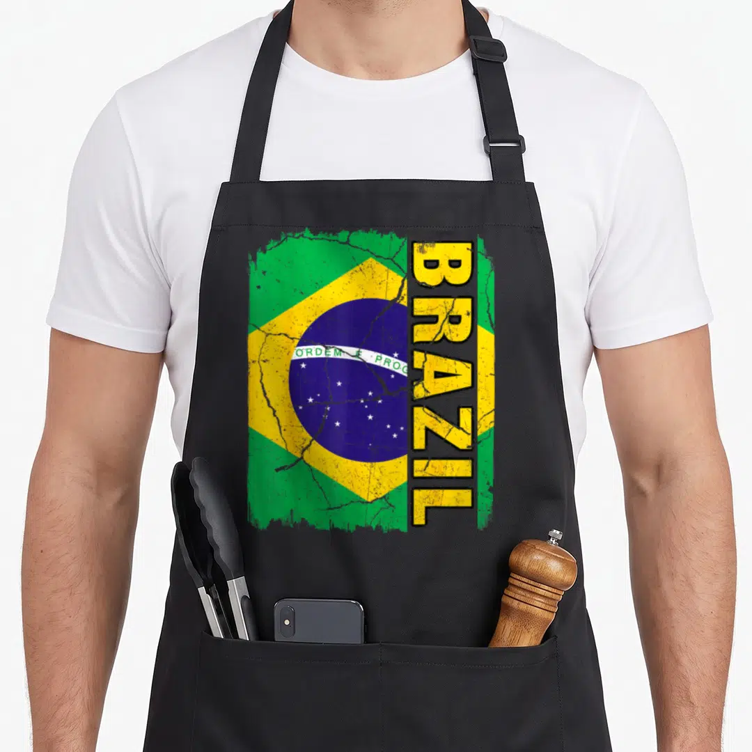 Brazilian flag pride apron - Distressed Brazil flag with vertical text and cracked globe details — shown on a black cotton canvas apron against a white background