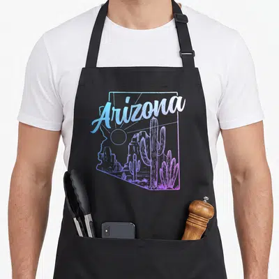 Cactus desert pride apron - Arizona state outline with cactus and sun graphic in gradient script — shown on a black cotton canvas apron against a white background