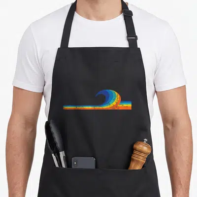 Wave surfer apron - Retro surfer silhouette inside a blue yellow orange and black curling wave graphic — shown on a black cotton canvas apron against a white background