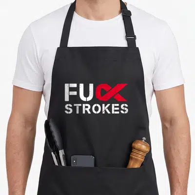 Stroke survivor awareness ribbon apron - Red ribbon K replacing FUC STROKES text in distressed white font — shown on a black cotton canvas apron against a white background
