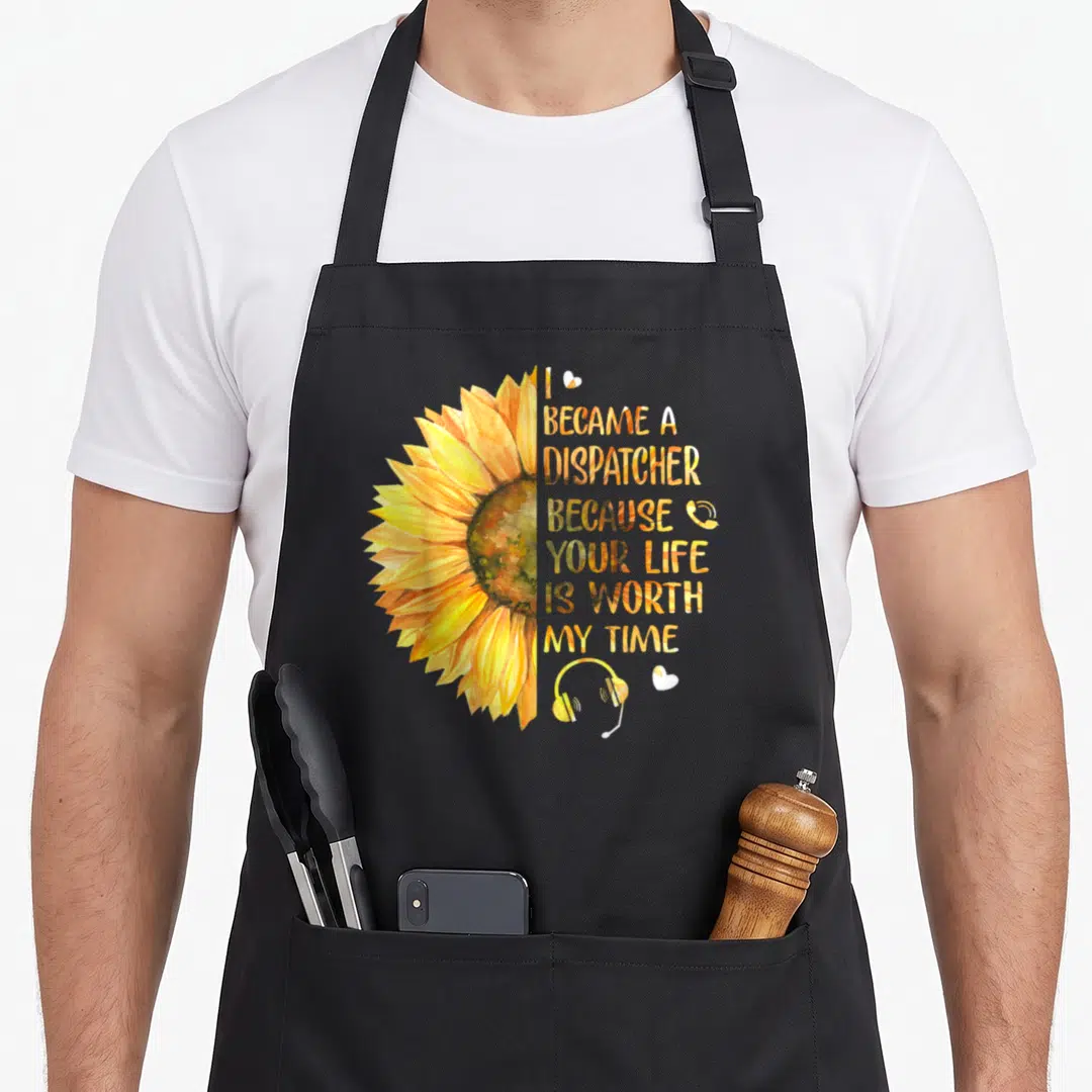 Became police life apron - Half sunflower watercolor print with dispatcher quote and headset icons — shown on a black cotton canvas apron against a white background