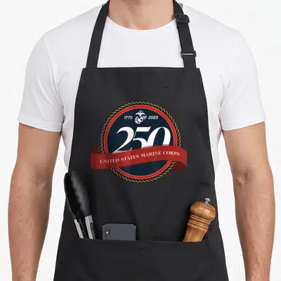 State birthday apron - USMC 250th anniversary seal with eagle globe anchor and red ribbon banner — shown on a black cotton canvas apron against a white background