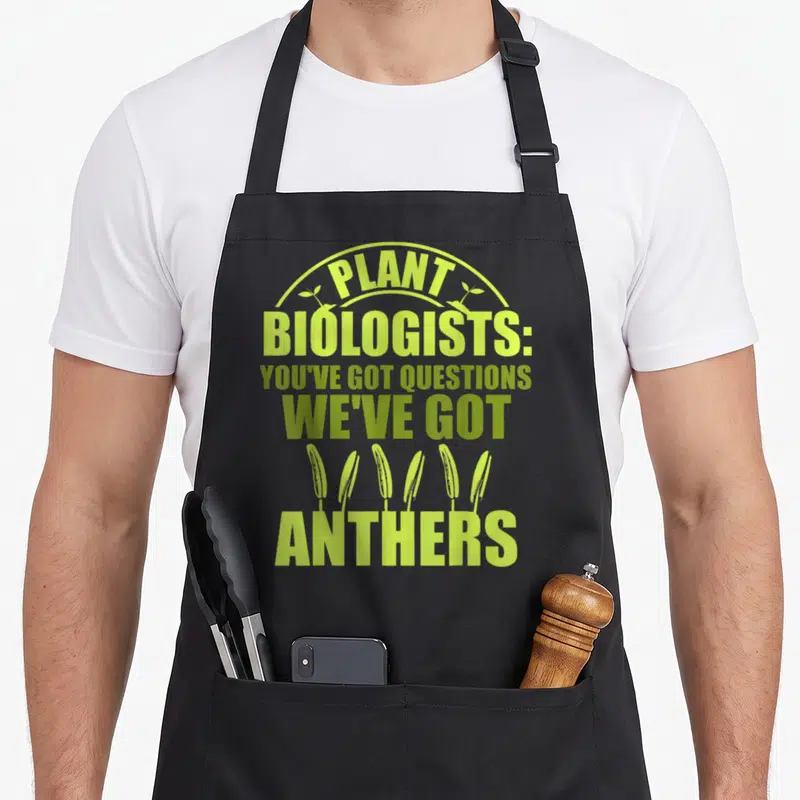 Botany plant apron - Lime green text reading Plant Biologists Youve Got Questions Weve Got Anthers with six anther — shown on a black cotton canvas apron against a white background