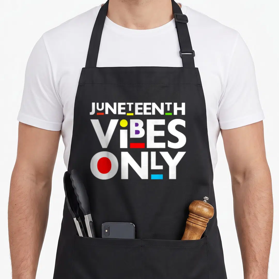 Juneteenth black apron - Stacked white JUNETEENTH VIBES ONLY text with red yellow green blue geometric accents — shown on a black cotton canvas apron against a white background