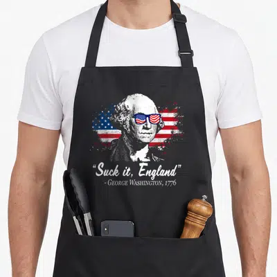 Suck england 4th of july apron - George Washington portrait in sunglasses with distressed flag and Suck it England quote — shown on a black cotton canvas apron against a white background