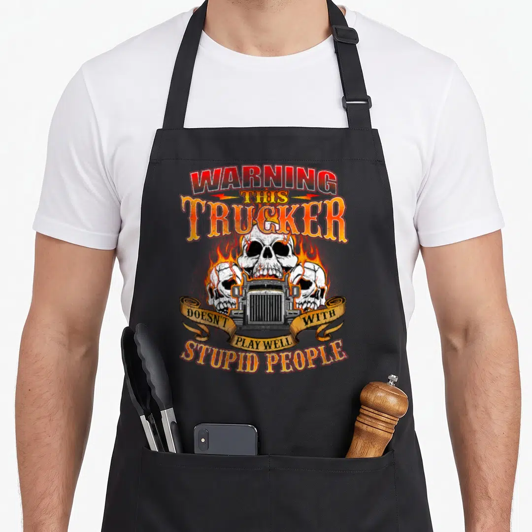 Play semi truck apron - Flaming skull and truck grille with warning text on black apron — shown on a black cotton canvas apron against a white background