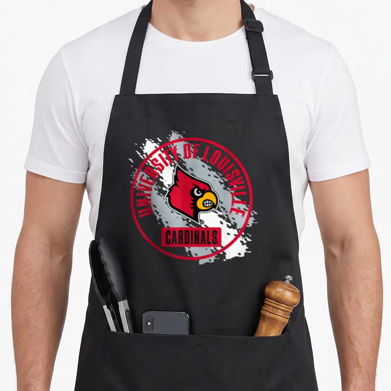 Elite paint apron - Red and white circular Louisville Cardinals logo with bird head and splatter background on black — shown on a black cotton canvas apron against a white background