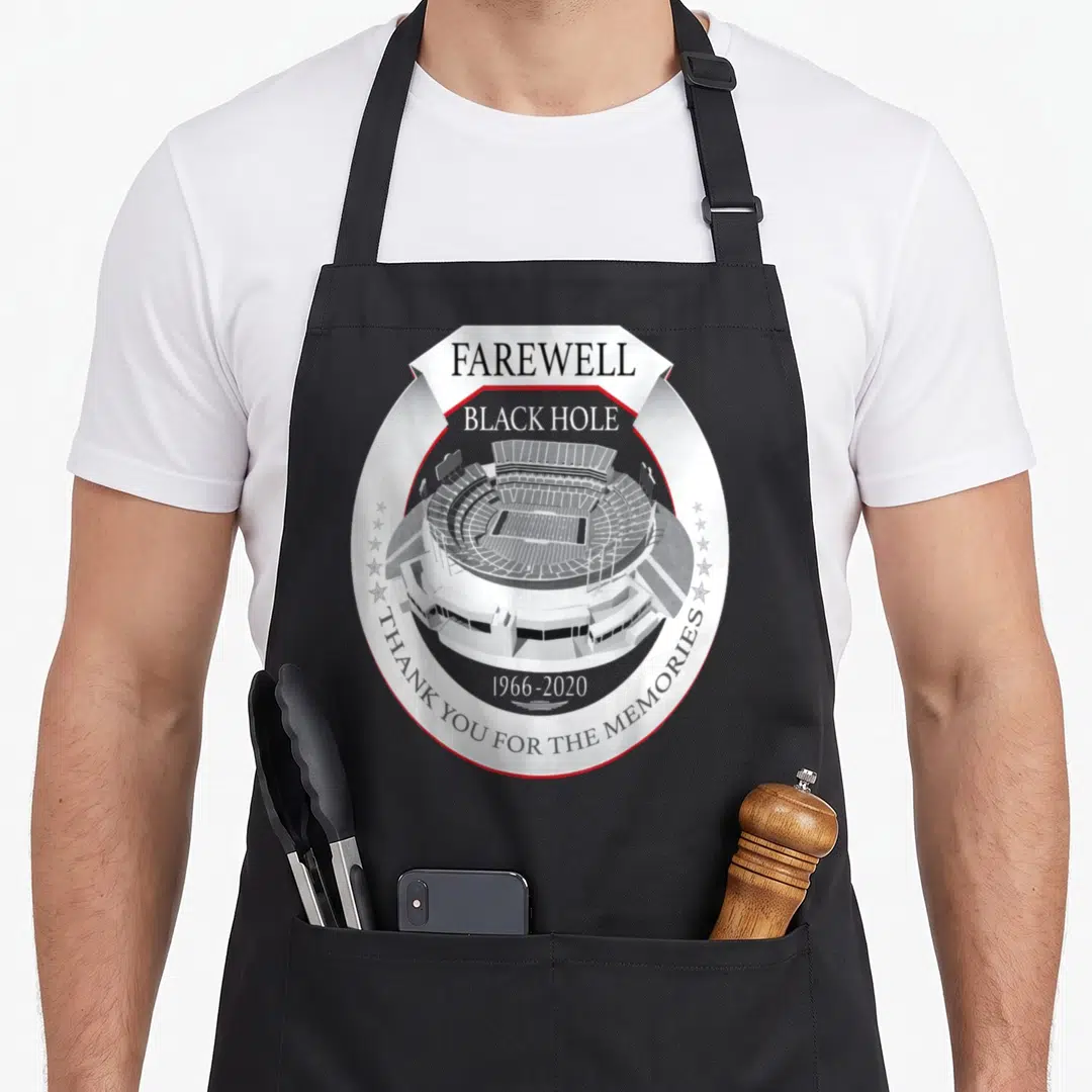 Okland black hole apron - Circular stadium emblem with farewell text and dates 1966-2020 in monochrome with red trim — shown on a black cotton canvas apron against a white background