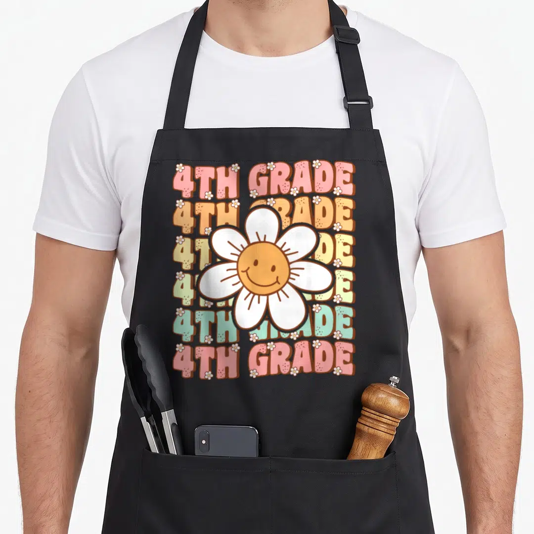 4th groovy grade apron - Six stacked rows of 4TH GRADE text with large smiling flower in pink orange yellow green teal — shown on a black cotton canvas apron against a white background