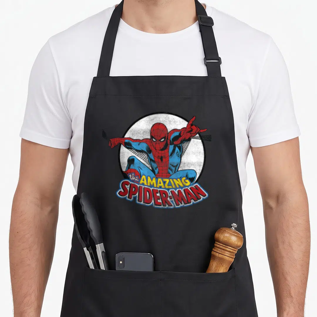 Circle animal apron - Spider-Man crouching in red and blue inside a white circle with stacked AMAZING SPIDER-MAN text — shown on a black cotton canvas apron against a white background