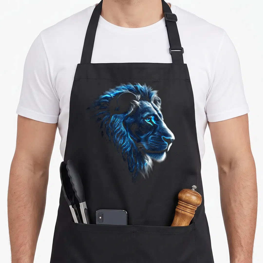 Artwork lion apron - Realistic blue and black lion head illustration centered on apron fabric — shown on a black cotton canvas apron against a white background