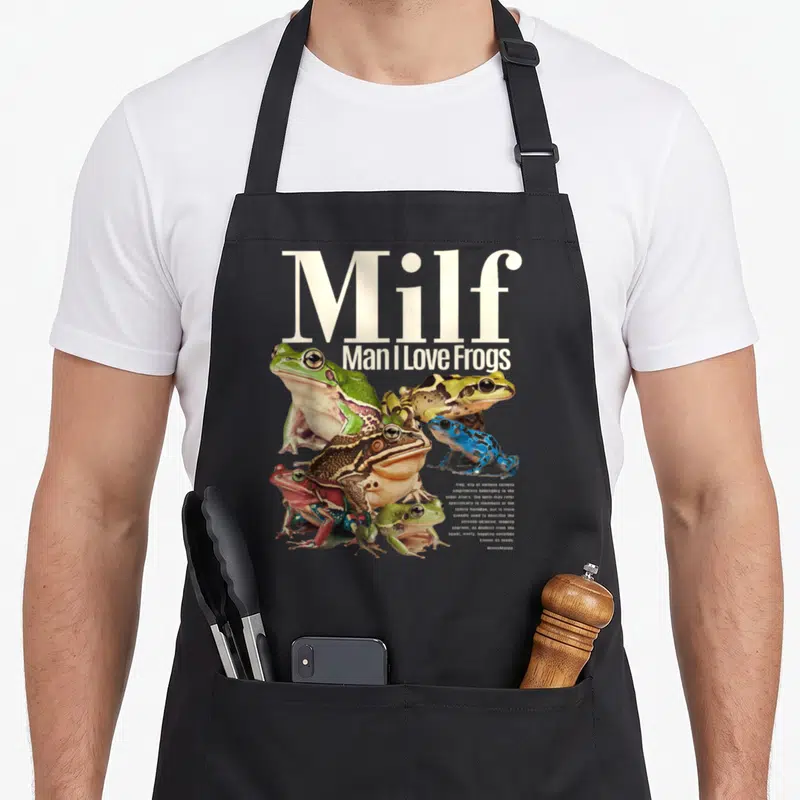 Cute milf frog aprons - Milf Man I Love Frogs pun with green blue brown frog photos and Anura definition text — shown on a black cotton canvas apron against a white background