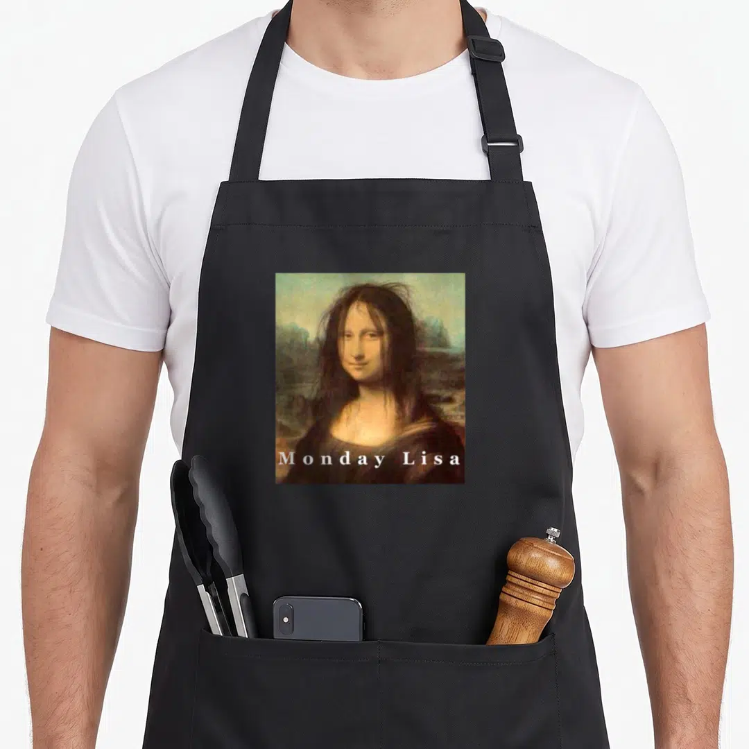Gioconda mona lisa apron - Mona Lisa portrait with messy hair and white Monday Lisa text across the bottom — shown on a black cotton canvas apron against a white background