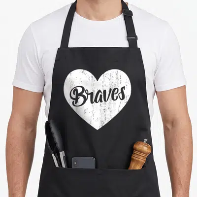 Brave big sister apron - Distressed white heart containing grey cursive Braves text on grey background — shown on a black cotton canvas apron against a white background
