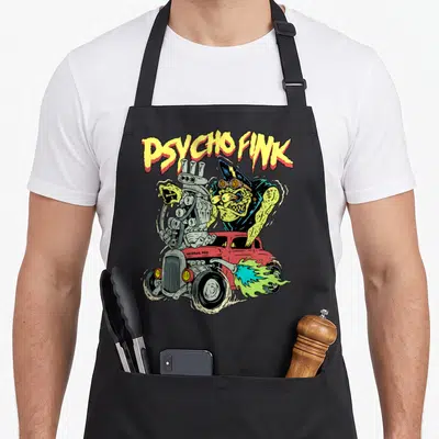 Hot rat rod apron - Green monster driving red hot rod with PSYCHO FINK text and exhaust flames — shown on a black cotton canvas apron against a white background