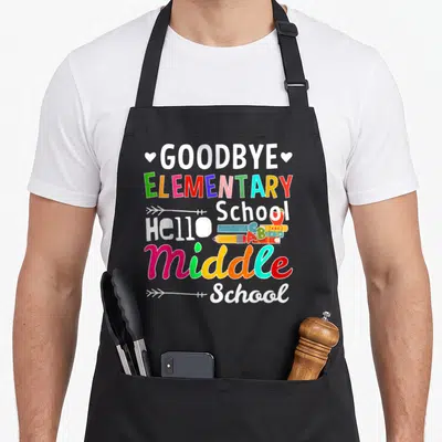 School hello apron - Goodbye Elementary Hello Middle School text with pencils books ruler and apple in white green — shown on a black cotton canvas apron against a white background