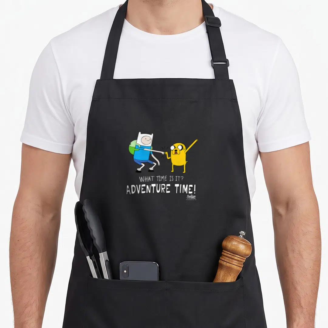 Adventure fist bump apron - Finn and Jake standing side-by-side above stacked text reading WHAT TIME IS IT? ADVENTURE — shown on a black cotton canvas apron against a white background