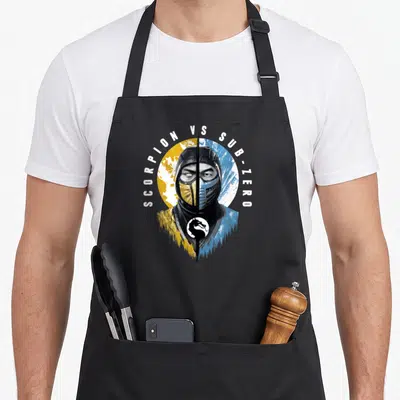 Klassic split apron - Split fighter face yellow blue SCORPION VS SUB-ZERO text arch dragon logo — shown on a black cotton canvas apron against a white background