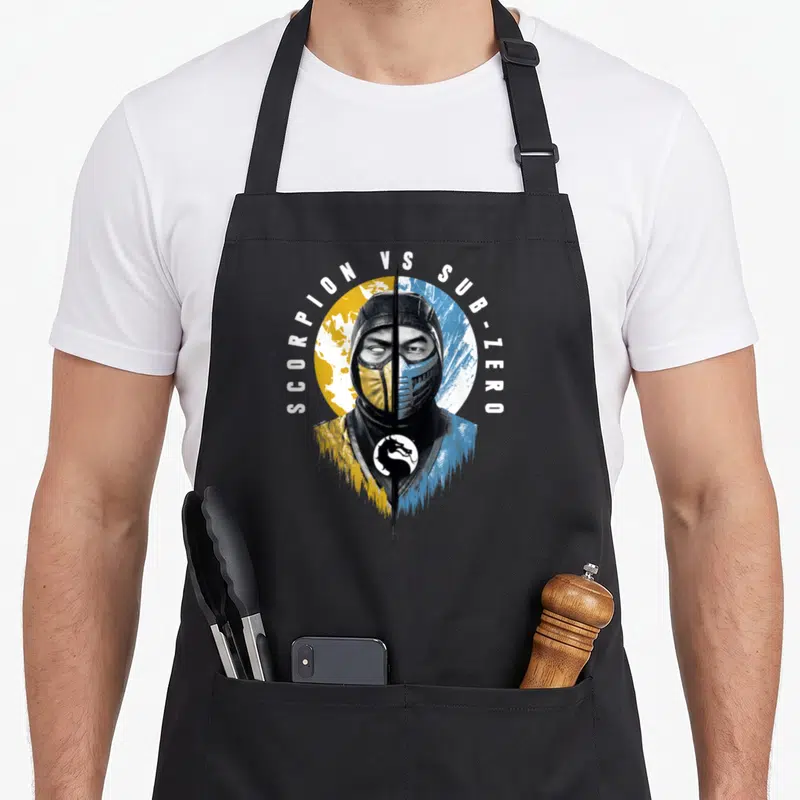 Klassic split apron - Split fighter face yellow blue SCORPION VS SUB-ZERO text arch dragon logo — shown on a black cotton canvas apron against a white background