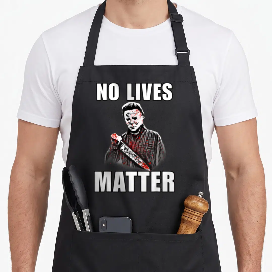 Live halloween apron - Michael Myers holding knife diagonally with NO LIVES MATTER text in white black red grey — shown on a black cotton canvas apron against a white background
