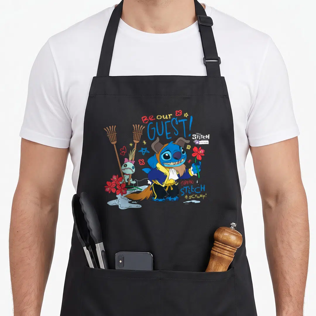Costume stitch apron - Stitch and Scrump cartoon characters with Be Our Guest and Starking Stitch Scrump text and brooms — shown on a black cotton canvas apron against a white background
