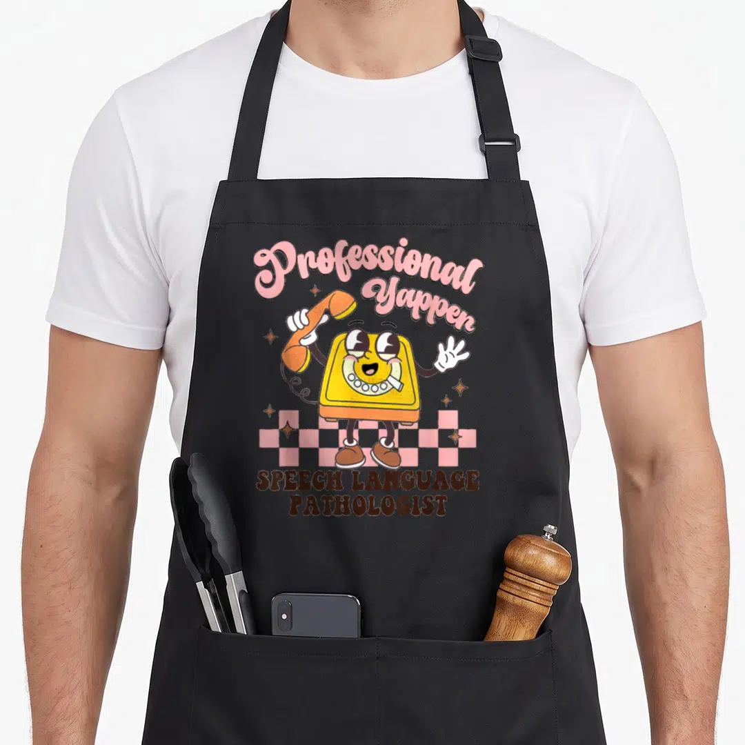 Yapper professional aprons - Cartoon yellow telephone with Professional Yappen text and checkerboard base — shown on a black cotton canvas apron against a white background