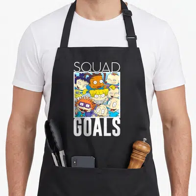 Goal squad apron - Rugrats character cluster between SQUAD and GOALS text in cartoon style — shown on a black cotton canvas apron against a white background