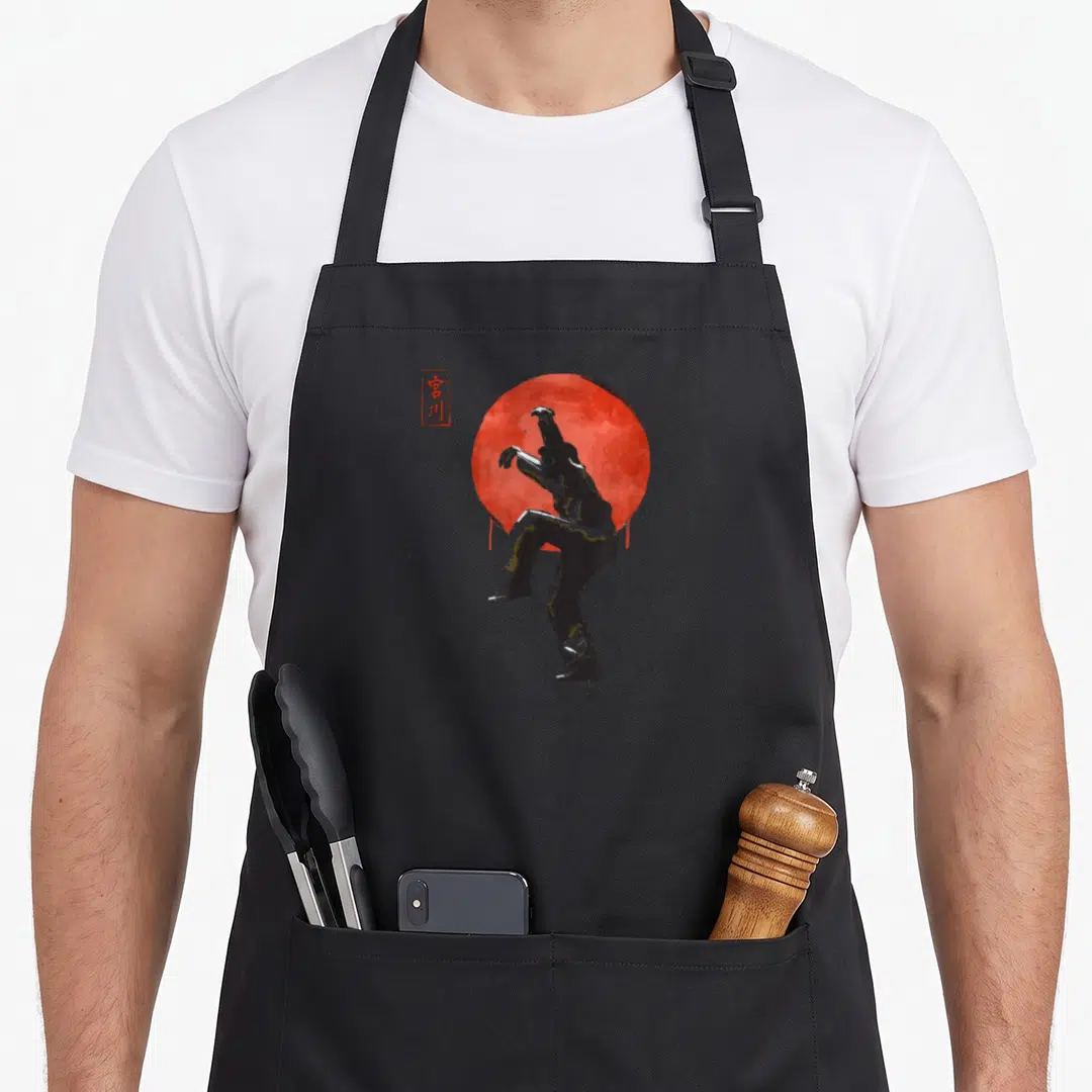 Karate kick off apron - Black watercolor martial artist silhouette against red circle with kanji text — shown on a black cotton canvas apron against a white background