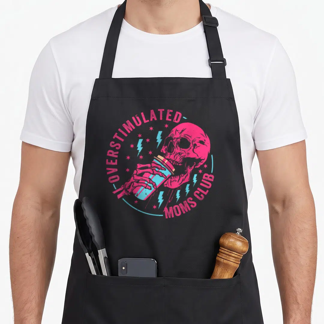 Overstimulated dad apron - Pink skeleton holding blue coffee cup with blue lightning bolts and arched text — shown on a black cotton canvas apron against a white background