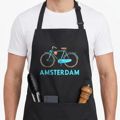 Amsterdam dutch aprons - Light blue bicycle with orange bag above AMSTERDAM text — shown on a black cotton canvas apron against a white background