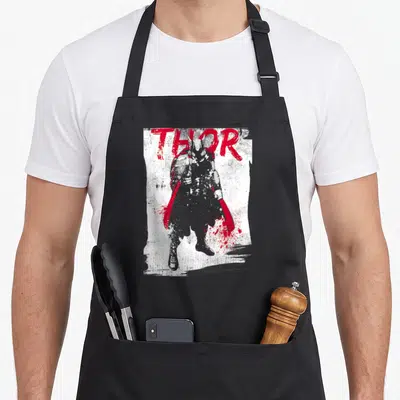 Grunge paint splatter apron - Grey Thor silhouette with red cape below large red THOR text on distressed white — shown on a black cotton canvas apron against a white background