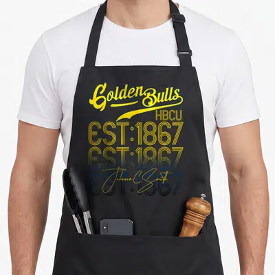 Johnson lover comfort apron - Stacked yellow and blue text reading Golden Bulls HBCU EST 1867 Johnson C Smith — shown on a black cotton canvas apron against a white background