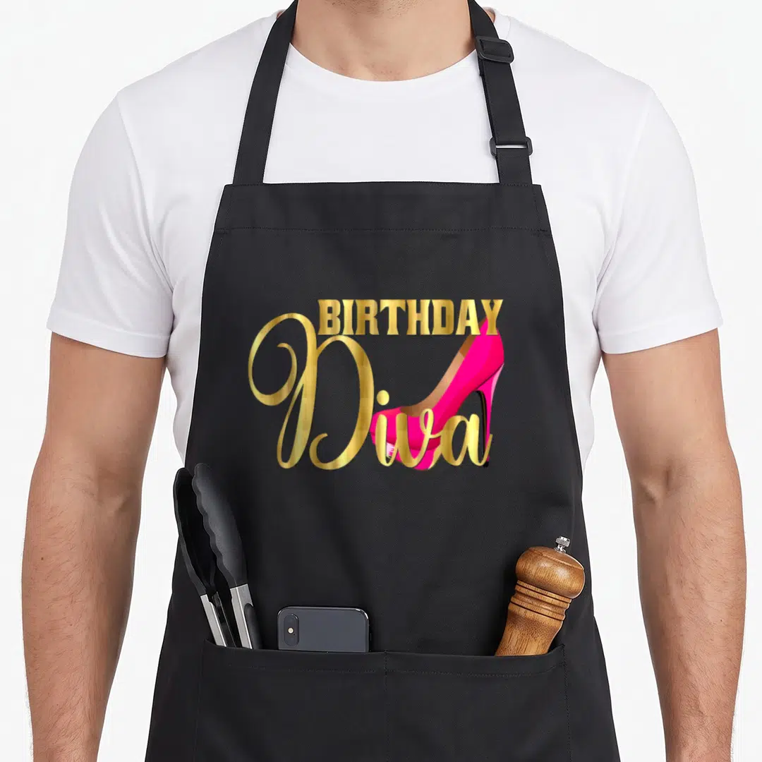 Diva 40th birthday apron - Gold BIRTHDAY Diva text with a pink high heel shoe on a black apron — shown on a black cotton canvas apron against a white background