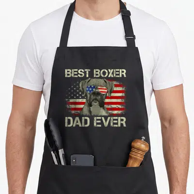 Boxer american flag apron - Dog wearing flag aviators with BEST BOXER DAD EVER text over distressed stripes — shown on a black cotton canvas apron against a white background