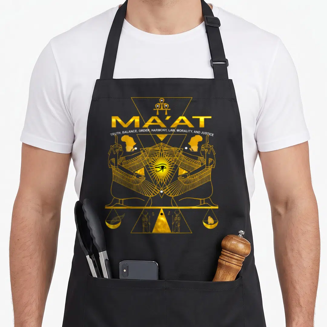 Akd egyptian apron - Gold line art Ma'at text with two figures, Eye of Horus, and heart feather scale inside geometric — shown on a black cotton canvas apron against a white background